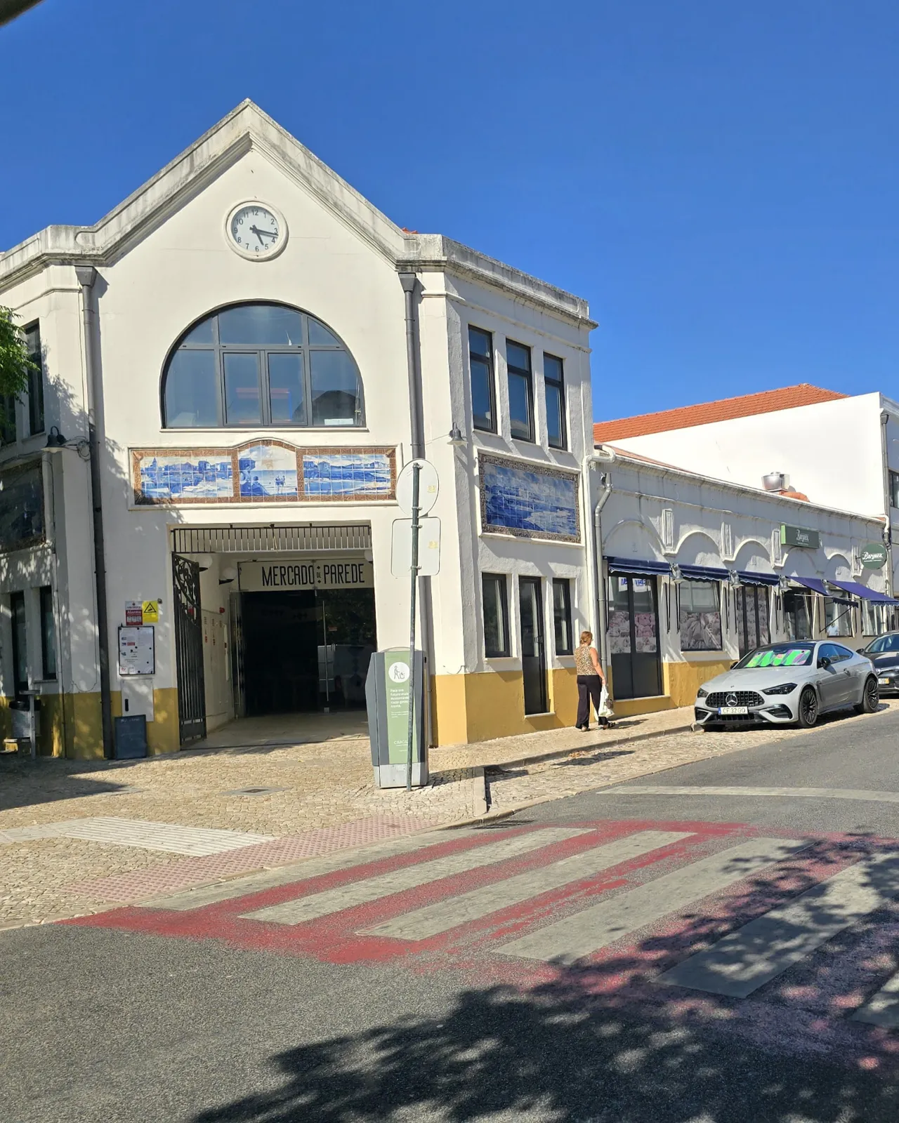 Edifício do Mercado da Parede, com painéis de azulejos e relógio na fachada.